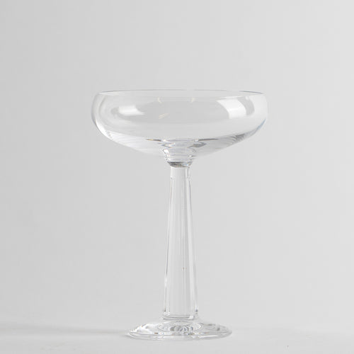 Verre transparent en verre avec tige et base circulaire sur fond gris clair
