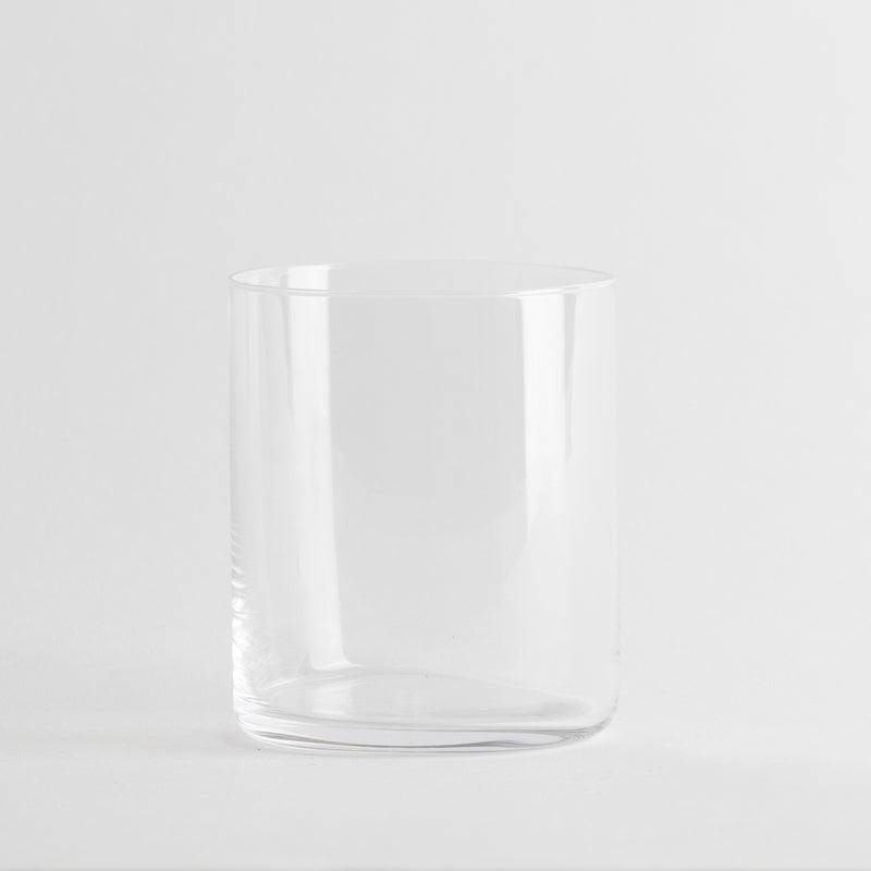 Transparentes zylindrisches Glas, ohne Verzierungen, auf neutralem weißem Hintergrund.