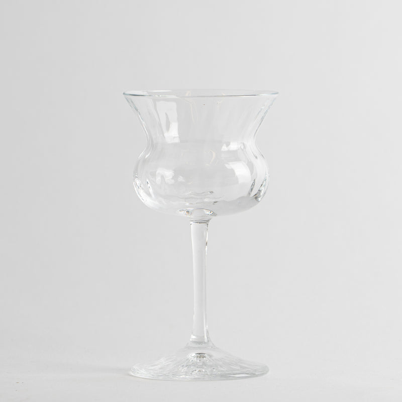Transparante glazen wijnglas met hoge steel en brede gevormde kom op uniforme lichte achtergrond