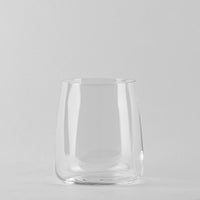 Transparant glas met ronde bodem en licht schuin lopende wanden op lichtgrijze achtergrond