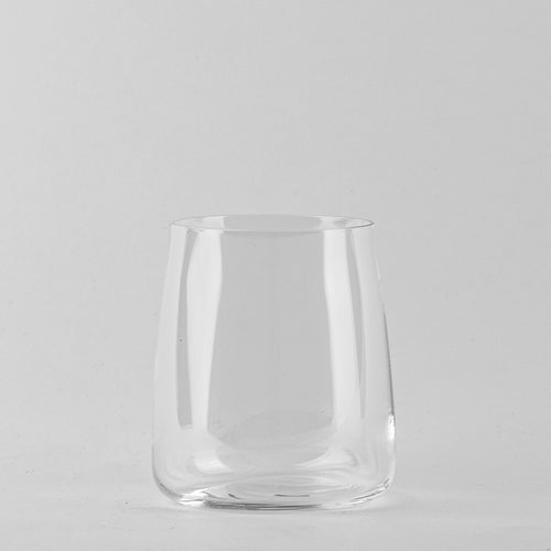 Transparant glas met ronde bodem en licht schuin lopende wanden op lichtgrijze achtergrond