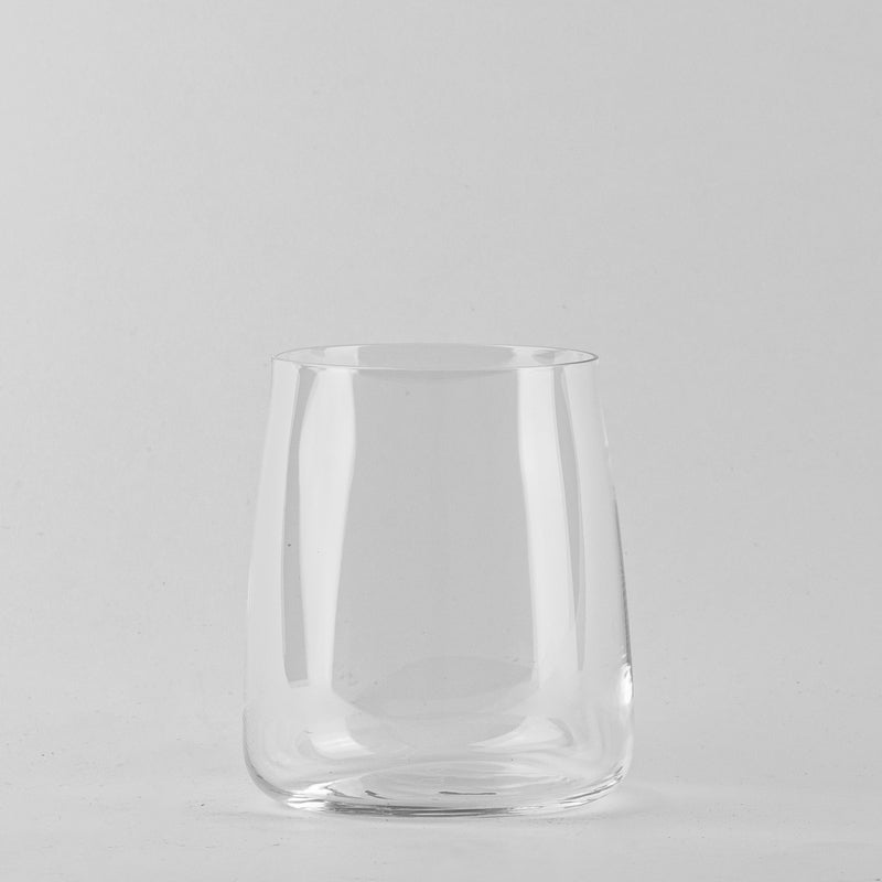 Transparant glas met ronde bodem en licht schuin lopende wanden op lichtgrijze achtergrond