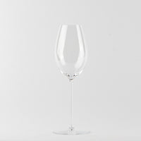 Transparante glazen wijnglas met lange steel en ronde voet op neutrale witte achtergrond