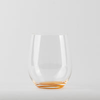 Verre transparent en verre avec base orange sur fond blanc