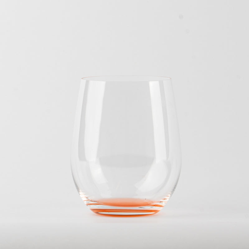 Verre transparent en verre avec base rouge sur fond blanc, sans liquide à l'intérieur.