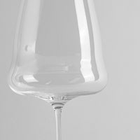 Transparent stem glass with slim stem on light grey background