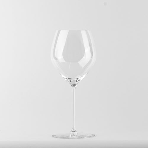 bicchiere da vino trasparente in vetro con calice ampio e gambo sottile su sfondo bianco