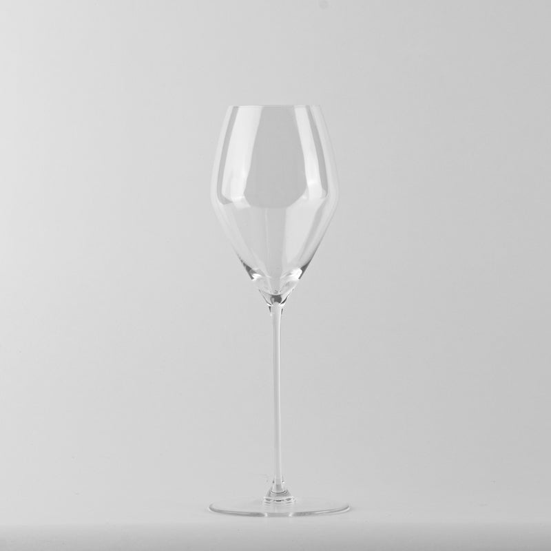 transparente copa de vino de vidrio csobre tallo fino y copa amplia sobre uniform light background