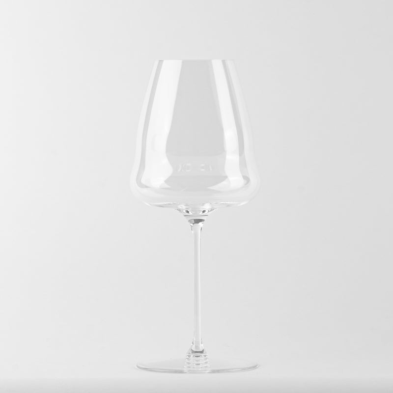 Calice en verre transparent avec large bord supérieur et pied fin, sur fond blanc.