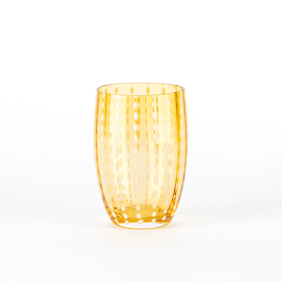 Cylindrical glass tumbler in glass transparent orange with decorazioni of punti bianchi verticali, on neutral white background.