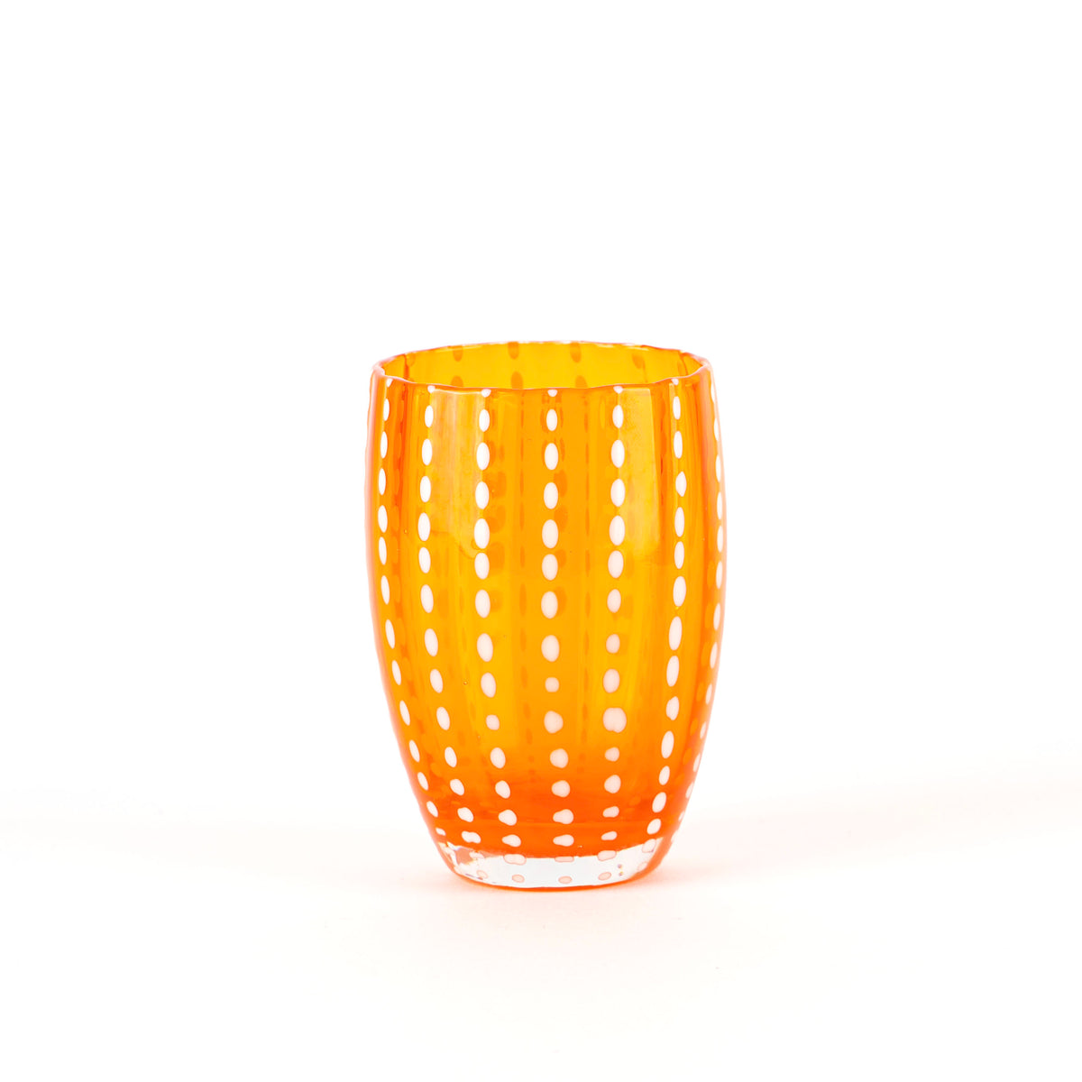 Orange glass tumbler in glass with vertical white dot stripe pattern, white background, slightly flared cylindrical shape.