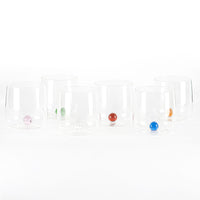Set di sei bicchieri in vetro trasparente con base sferica colorata, su sfondo bianco.