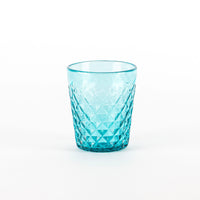 Verre turquoise en verre transparent avec surface givré et décoration à motif géométrique sur fond blanc