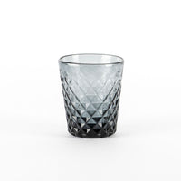 Verre transparent avec dégradé gris et motif en relief à losanges, fond épais, fond blanc.