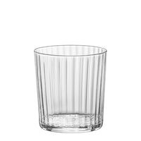 Transparant glas met verticaal geribbelde oppervlakken, dikke bodem en cilindrische vorm.