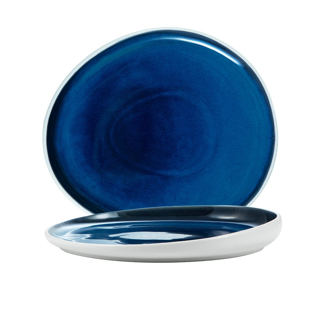 twee ronde keramische borden met glanzend blauw interieur en mat witte rand, witte achtergrond