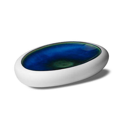 Oval plate with matte white rim and glossy glazed interior shaded from blue to green, on neutral white background
