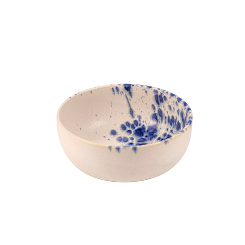 ciotola tonda in ceramica beige con decorazioni irregolari blu all'interno e su un lato del bordo, sfondo bianco