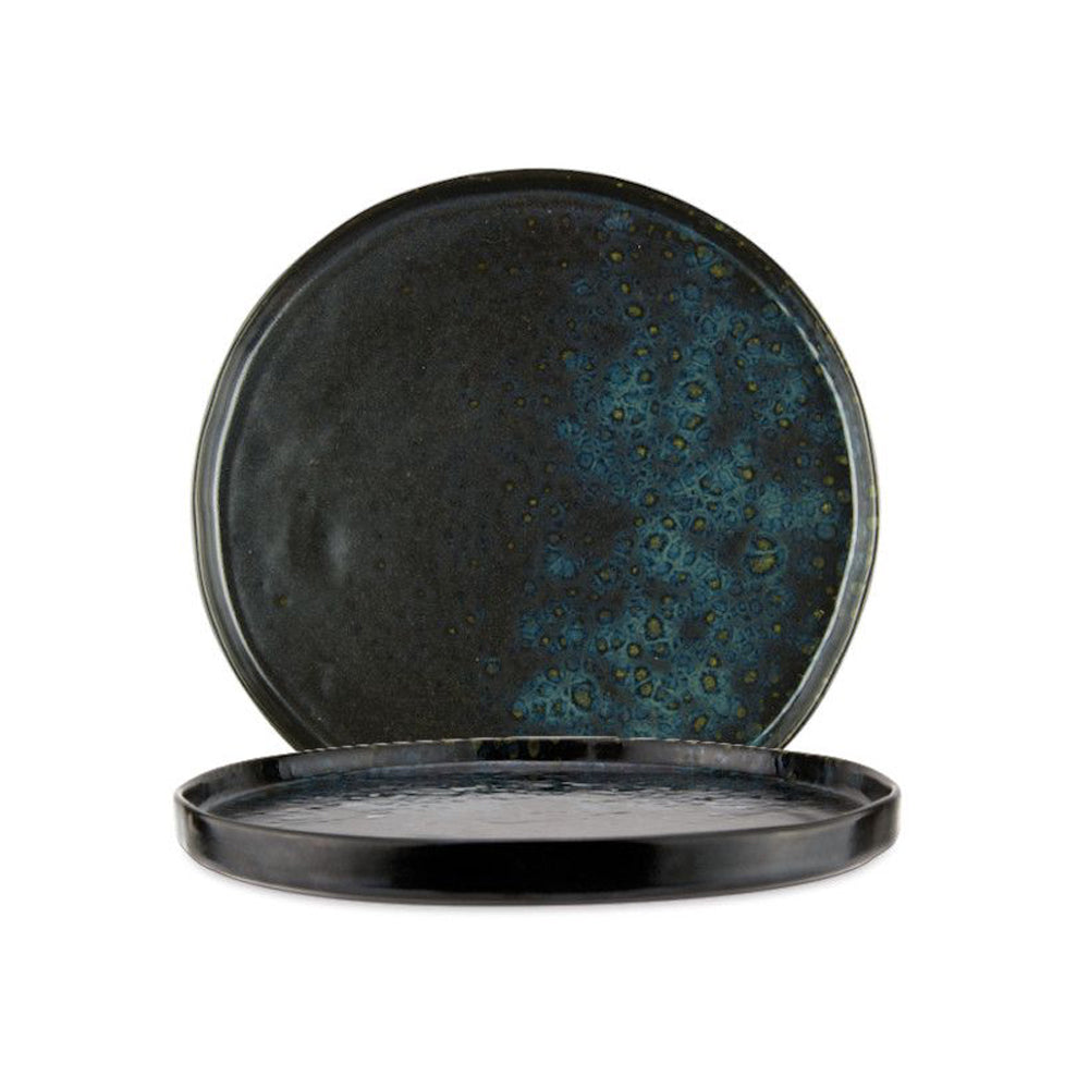 deux assiettes rondes en céramique noire et bleue avec effets tachetés, surface brillante, fond blanc