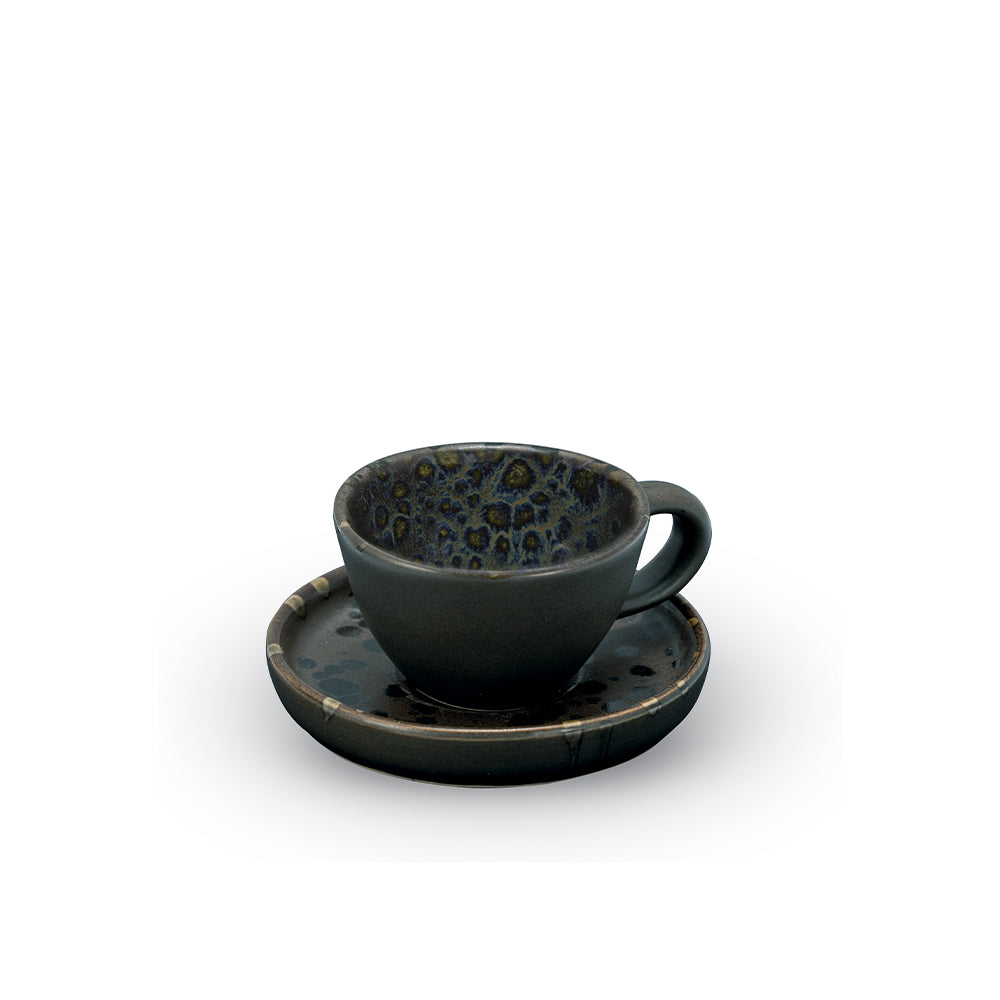 Tazzina da caffè in ceramica nera opaca con interno a macchie blu e marrone, accompagnata da un piattino coordinato.