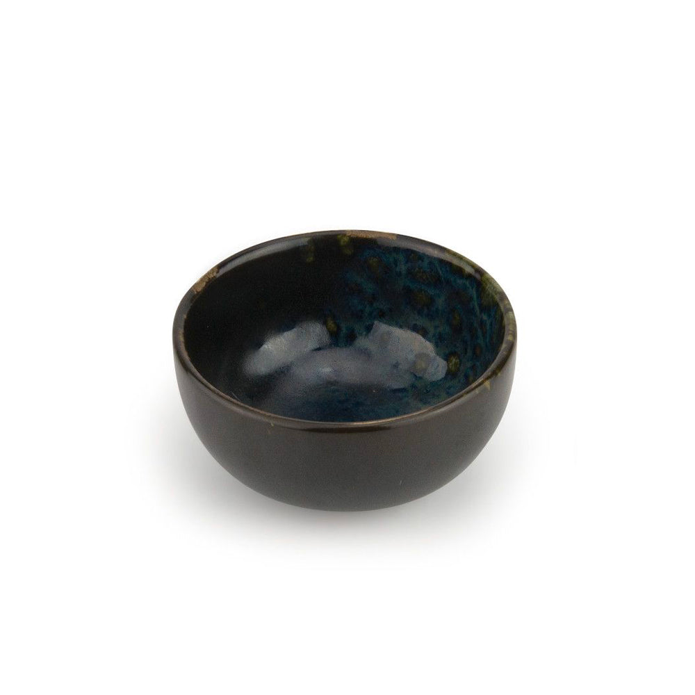 Ronde glanzende keramische kom met zwarte buitenkant en gemarmerd blauw interieur met groene reflecties op witte achtergrond