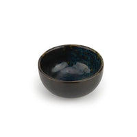 Round black glazed ceramic bowl with blue interior and glossy reflections, on isolated white background
