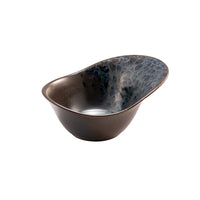 Irregular glazed ceramic bowl in dark blue, black and brown tones with glossy finish isolated on white background