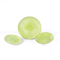 Tre piatti in ceramica verde pastello con motivi a spirale, uno grande al centro e due più piccoli ai lati, su sfondo bianco.