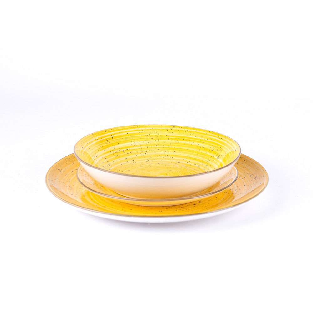 Piatti di ceramica con tonalità gialla e nera, uno concavo e uno piano, su sfondo bianco.
