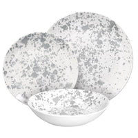 Set di piatti bianchi con decorazioni macchiate grigie, composto da un piatto fondo, un piatto piano e un piatto da dessert.