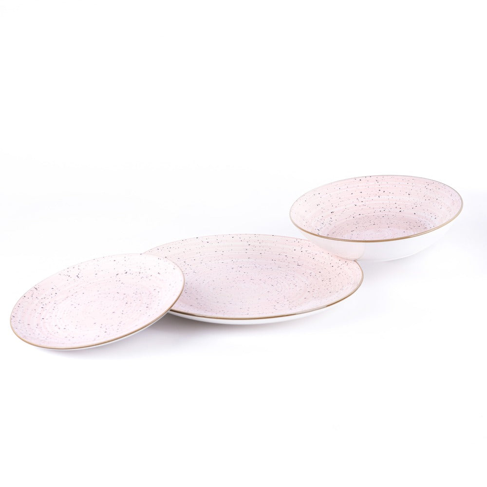 Tres platos de cerámica en tonos rosa claro, con puntos negros y borde dorado, dispuestos sobre fondo blanco.