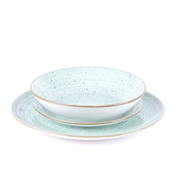 Set de platos de cerámica, verde agua con motivos de lunares negros y borde dorado, compuesto por un plato hondo y uno plano.