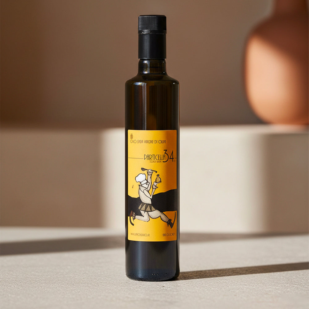 Bouteille en verre sombre avec étiquette jaune représentant un dessin stylisé de chef et texte Olio Extra Vergine di Oliva Particella 34