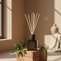Diffusore di fragranza Culti Mediterranea marrone con bastoncini su mattoni, foglie verdi, ambiente interno con luce naturale.