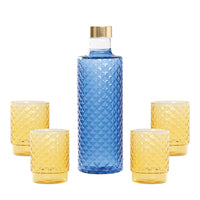 Bottiglia blu con tappo dorato e tre bicchieri gialli, tutti con una superficie a rombi. Sfondo bianco.