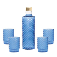 Bottiglia alta in vetro blu con tappo dorato e quattro bicchieri coordinati, tutti con motivo a diamante.