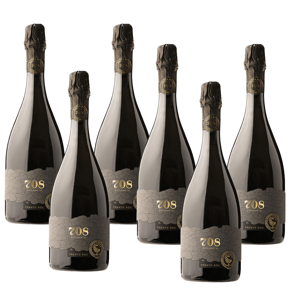 Zes mousserende wijnflessen met zwart-gouden label, op een rij op witte achtergrond.