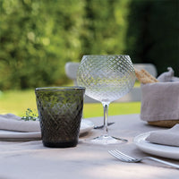 eau glass en verre dark vert et verre à vin in transparent glass avec faceted surface sur outdoor set table