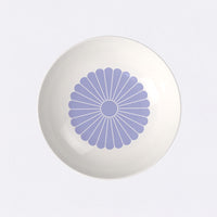 piatto rotondo bianco con decorazione floreale centrale a raggiera viola, materiale ceramico lucido, sfondo chiaro uniforme