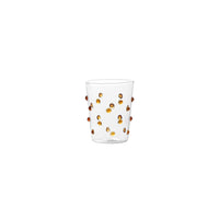 Verre transparent en verre avec reliefs ronds orange distribués sur toute la surface, fond blanc.