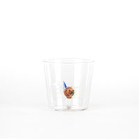 Transparent tumbler with a small animal figure inside, brown and blue in color. White background.