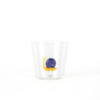 Transparent tumbler with a blue and yellow snail decoration on the base. White background.