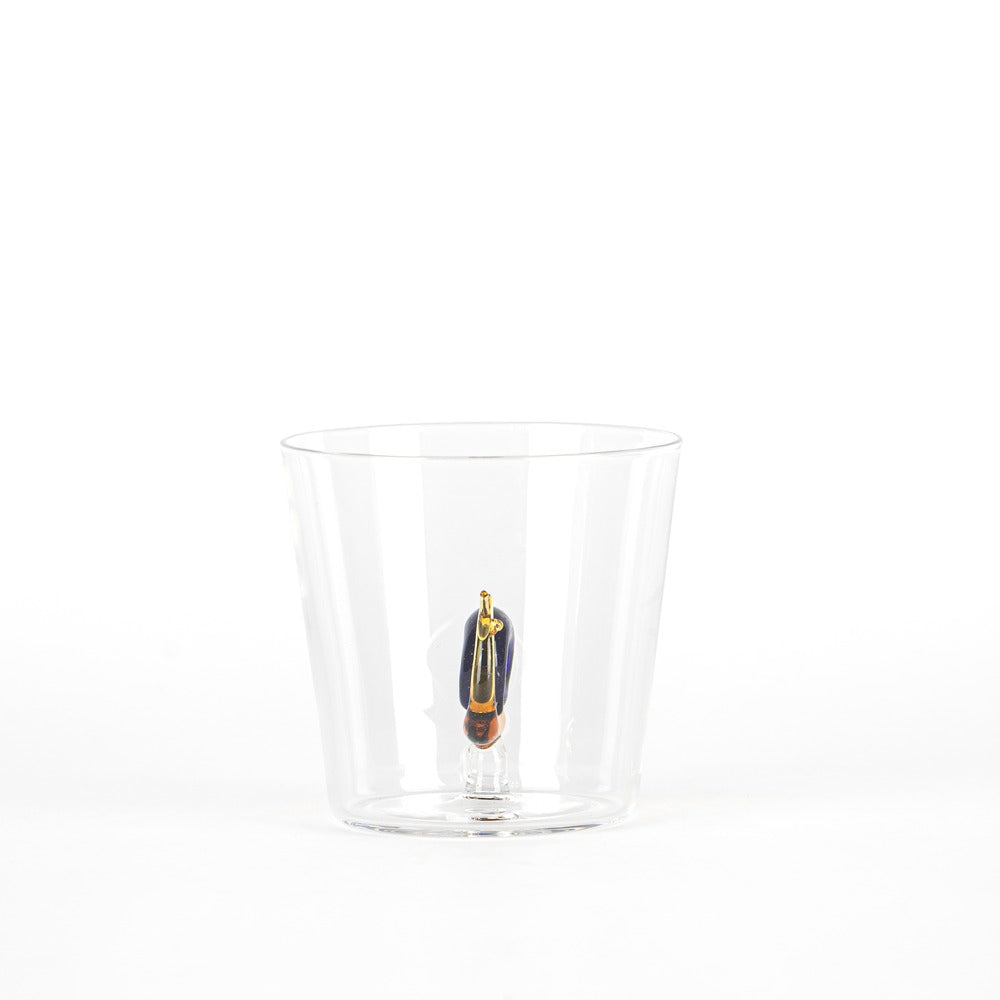 Transparent tumbler with colored figure inside, composed of blue, gold and orange details, on white background.