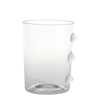 Verre transparent avec trois éléments saillants blancs sur le côté droit, forme cylindrique, matériau verre.