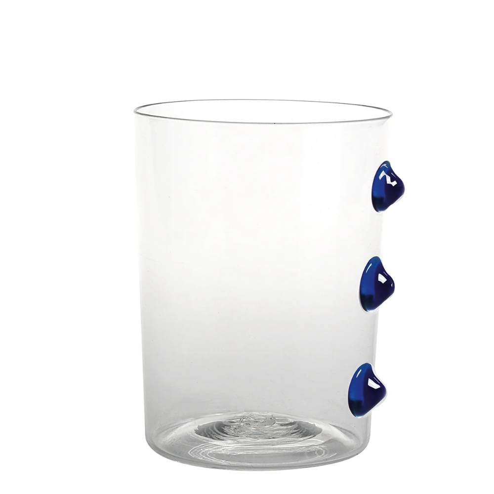 Verre transparent cylindrique avec trois décorations bleues saillantes sur un côté, fond blanc uniforme