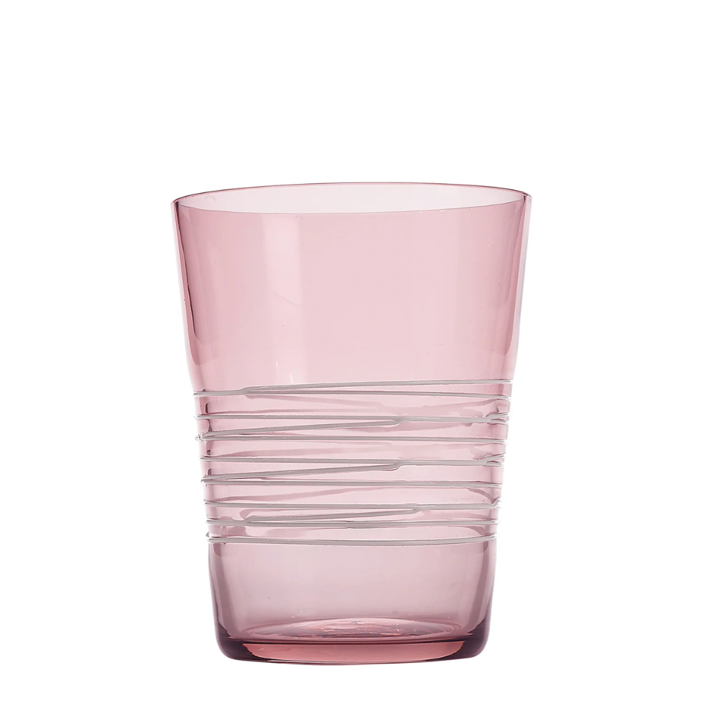 Bicchiere di vetro rosa trasparente con corpo decorato da linee orizzontali irregolari, sfondo bianco.