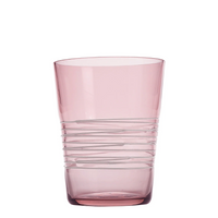 Bicchiere di vetro rosa trasparente con corpo decorato da linee orizzontali irregolari, sfondo bianco.