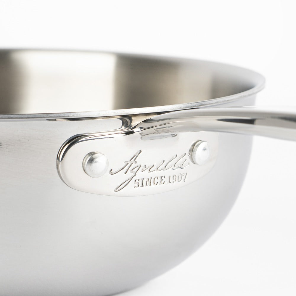 Pentola in acciaio inox lucido con manico e logo "Agnelli since 1907" visibile. Fondo chiaro e rotondo. Ambientazione neutra.