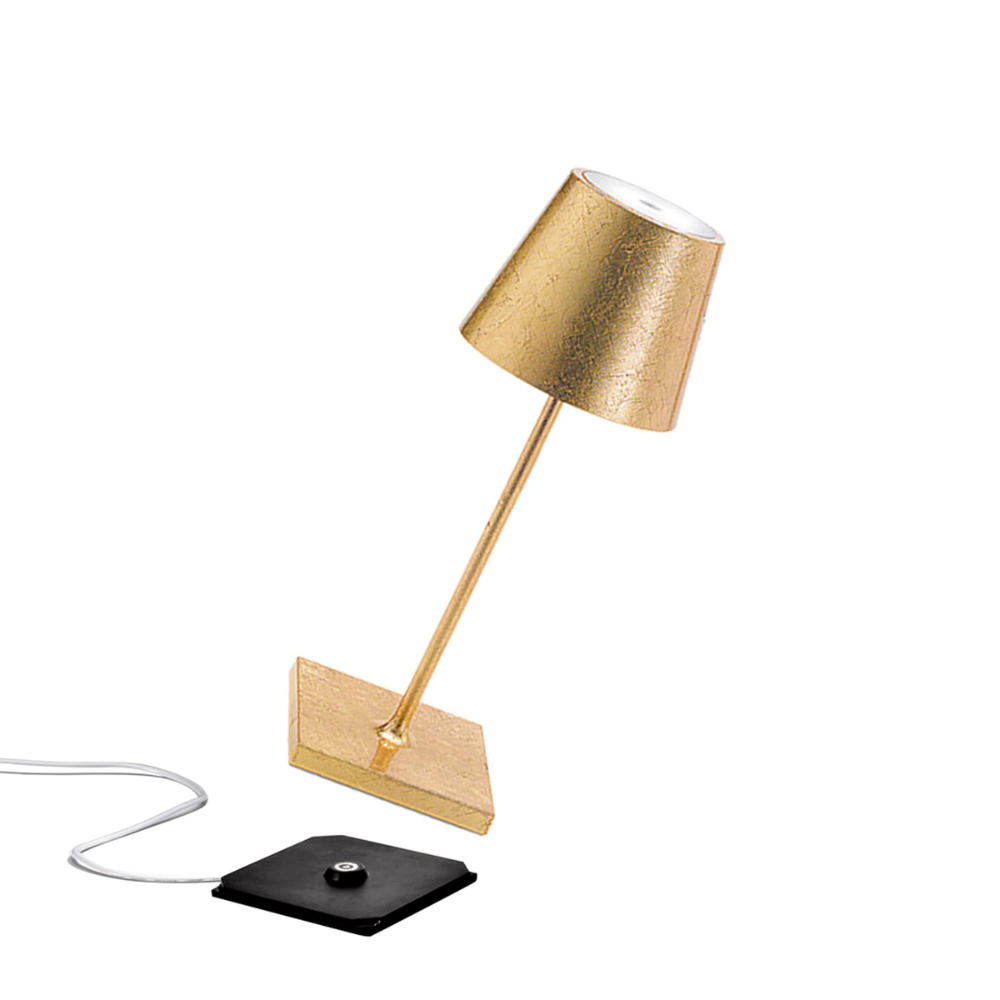lampada da tavolo dorata in metallo con paralume a cono, base quadrata dorata e interruttore nero su cavo trasparente
