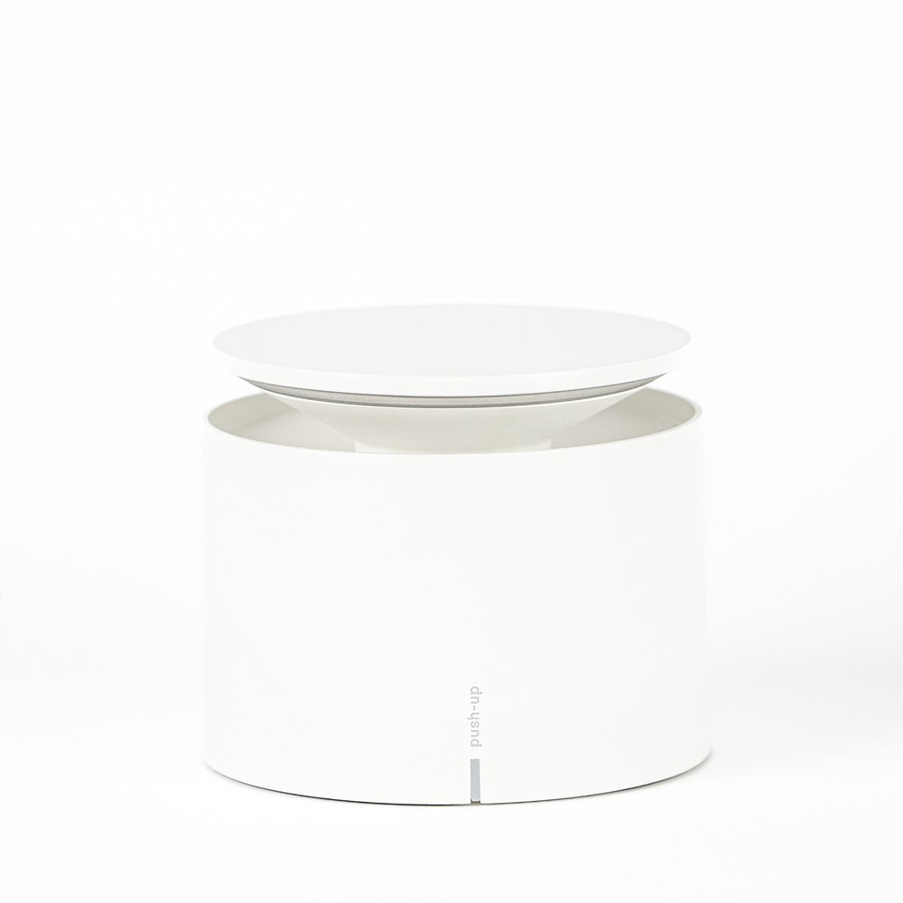 White round container with disc lid, smooth surface and empty interior. Minimalist setting.